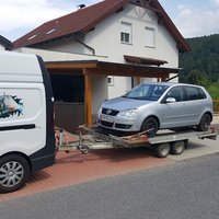 Kleintransporter mit einem Kleinwagen auf dem Anhänger