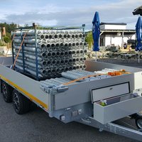 Anhänger transportiert riesen Metallschrauben